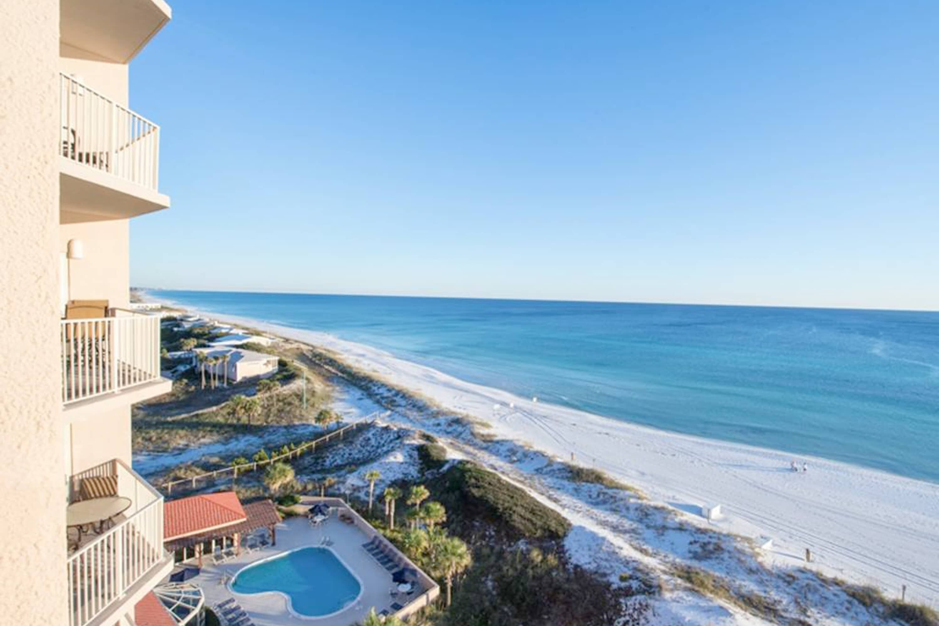 A beachfront hotel with a swimming pool, beach access, and a clear view of the ocean.