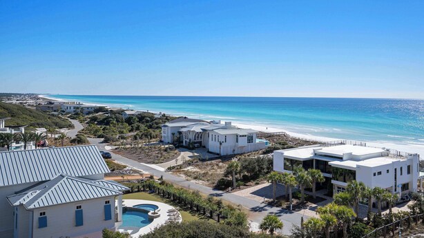 Une propriété située sur la côte, dotée d’une piscine, d’une architecture moderne et offrant une vue sur la plage.