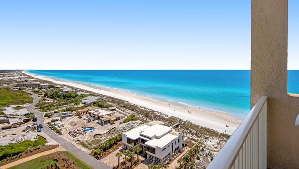 A coastal view with a beach, a clear sky, and a building with a flat roof and large windows. - Exclusive 3BR Beachfront with Gulf Views (Miramar Beach)