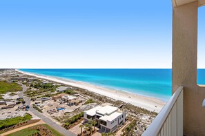 A coastal view with a beach, a clear sky, and a building with a flat roof and large windows. - Exclusive 3BR Beachfront with Gulf Views (Miramar Beach)