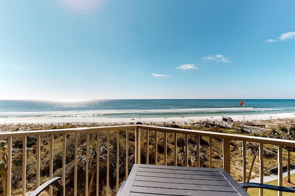 A beach view from a wooden deck with a railing, overlooking the ocean and beach. - Beachfront condo with Gulf views & private balcony (Miramar Beach)