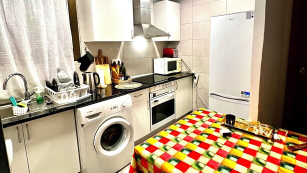Una cocina compacta equipada con lavadora, microondas y refrigerador.