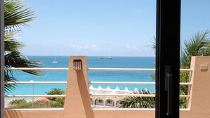 A balcony with a view of the ocean and a ship in the distance. - 5BR Villa, Pool & Little Bay Views (Little bay)
