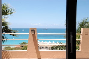 A balcony with a view of the ocean and a ship in the distance. - 5BR Villa, Pool & Little Bay Views (Little bay)