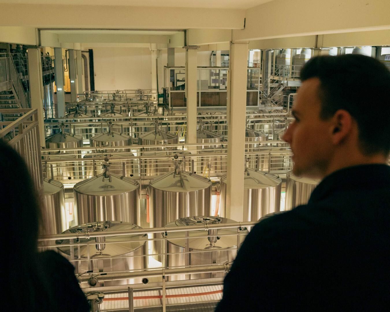 A large industrial facility with multiple stainless steel tanks and pipes.