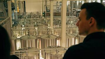 A large industrial facility with multiple stainless steel tanks and pipes.