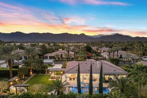Zona residenziale con case, piscina e montagne sullo sfondo.