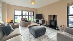 Un salon moderne avec un canapé, un pouf et une cheminée.