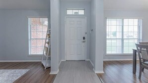 A hallway with a white door, a small window, and a wooden floor. - Luxury Harker Hideaway Relax, Unwind, Ex (Harker Heights)