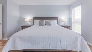 A bedroom with a large bed, two bedside tables with lamps, a ceiling fan, and a window with blinds. - Luxury Harker Hideaway Relax, Unwind, Ex (Harker Heights)