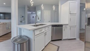 A modern kitchen with white cabinetry, stainless steel appliances, and pendant lighting. - Luxury Harker Hideaway Relax, Unwind, Ex (Harker Heights)