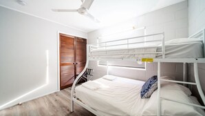 A bunk bed room with a ceiling fan, a wooden door, and a white wall. - Comfy Kirwan Getaway (Kirwan)