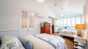 A room with two beds, a dresser, a desk, and a window. - Tropical getaway 10 min to city Vacation Home in Hermit Park (Hermit Park)