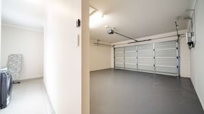 Un garage propre et vide, avec un sol gris et une porte de garage fermée.