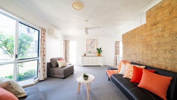 Een moderne woonkamer met een bank, een salontafel en een open haard.