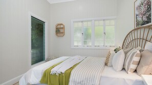 A bedroom with a bed, a window, and a door. - Grand 4BR Queenslander on Harold Sleeps 7 (West End)