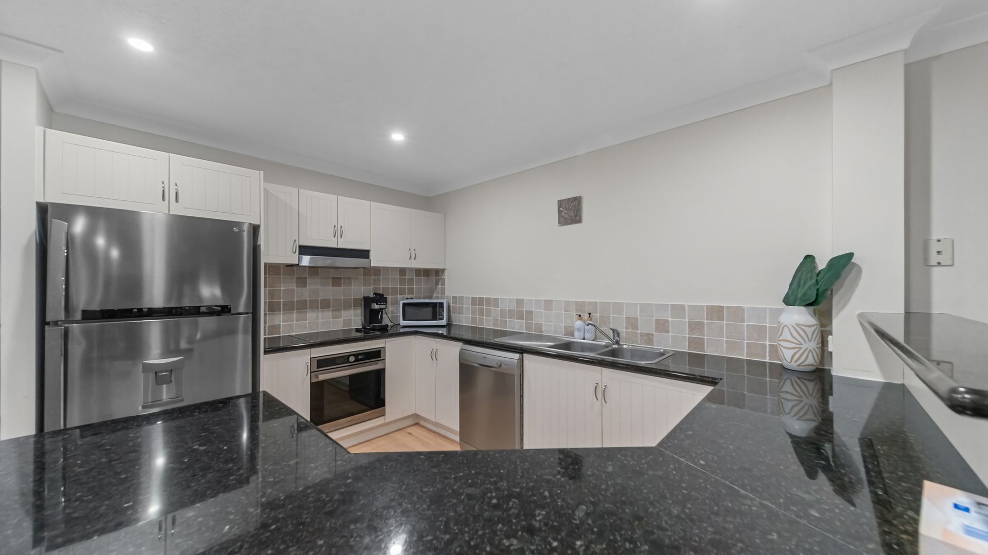 A modern kitchen with stainless steel appliances, a microwave, and a dishwasher.