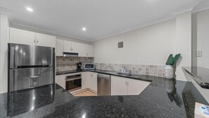Una cocina moderna con electrodomésticos de acero inoxidable, microondas y lavavajillas.