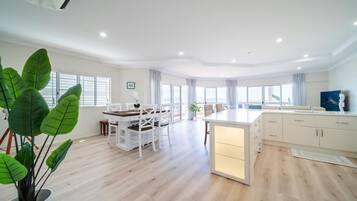 A spacious living area with a dining table, chairs, and a kitchen island with cabinets.