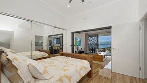 Un dormitorio moderno con una cama grande, un espejo y un balcón con vistas.