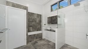 Un baño moderno con bañera, lavabo y ducha.