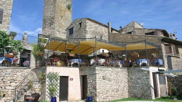 A stone building with a tower, outdoor seating area, and a pool. - Le Logis du Guetteur (Les Arcs-sur-Argens)