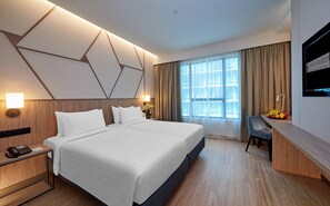 Una habitación de hotel moderna con una cama grande, un escritorio y un televisor.