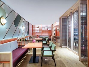 Un ambiente moderno con posti a sedere, tavoli ed elementi decorativi.