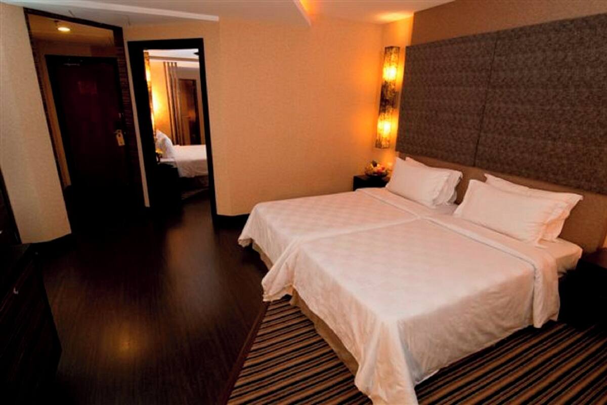 Ein Hotelzimmer mit einem großen Bett, einem Nachttisch und einer Wandleuchte.