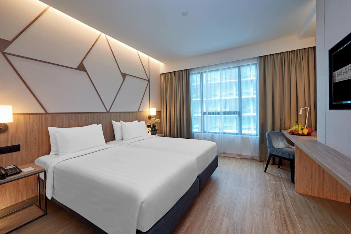 Ein modernes Hotelzimmer mit einem großen Bett, einem Schreibtisch und einem Fernseher.