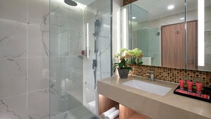 A modern bathroom with a glass-enclosed shower, a marble-tiled wall, a wooden vanity, and a large mirror. - Grand Mercure Kuala Lumpur Bukit Bintang (Kuala Lumpur)