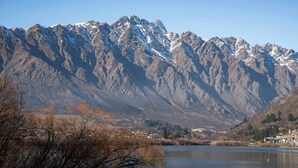 A mountainous landscape with a lake and a small settlement. - Lakeside Studio Retreat (Queenstown)