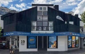Un hotel moderno con fachada oscura, ventanas grandes y un letrero que dice "Hotel".