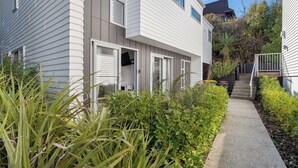 Ein zweistöckiges Wohnhaus mit einer überdachten Veranda und einem Betonweg, der zur Eingangstür führt.