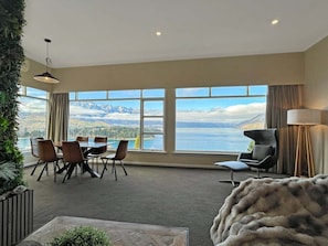 A spacious room with a large dining table, chairs, and a view of mountains and a lake. - The Biggest & Best Views, 3 Bedrooms, Walk To Town (Queenstown)