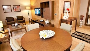 A modern living room with a round dining table, two sofas, a TV, and a decorative vase. - Tunel Residence (Istanbul)