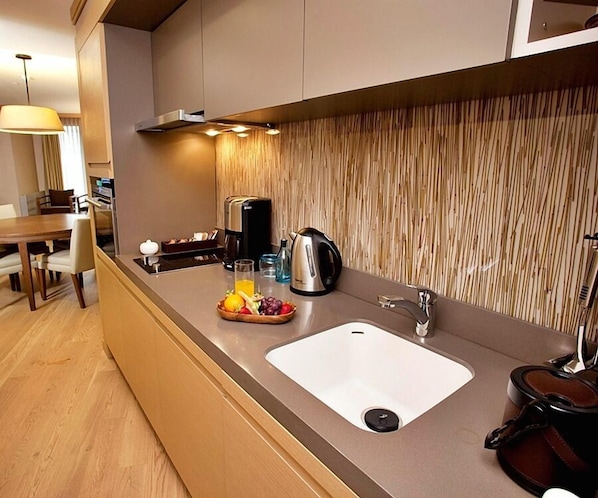 A modern kitchen with a built-in sink, a kettle, and a fruit bowl on the counter. - Tunel Residence (Istanbul)