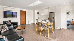 A modern apartment with a living room, dining area, kitchenette, and a bedroom. - Central Charm | 10 Min Walk to CBD (Queenstown)
