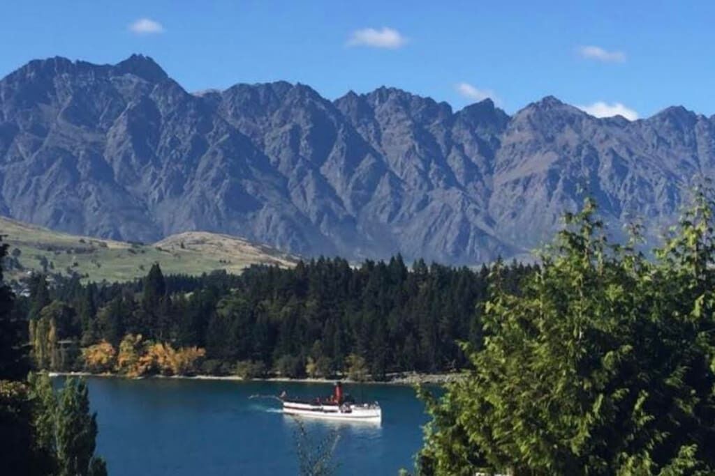 A boat on a lake with mountains in the background.