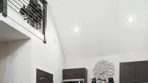 A compact kitchen with a central island, dark cabinetry, and a modern stove. - The Kinky Cabin Adult Themed A-Frame (Walker County)