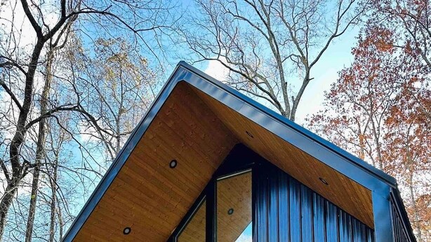 A modern building with a sloped roof, large windows, and a wooden exterior. - The Kinky Cabin Adult Themed A-Frame (Walker County)