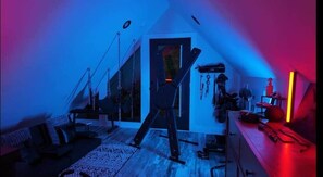 Una habitación con techo inclinado, una cama, un escritorio y una ventana.
