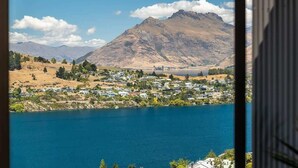 Un lago con una montaña al fondo y una zona residencial en primer plano.