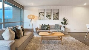 Una sala de estar moderna con un sofá, una mesa de centro y decoración en las paredes.