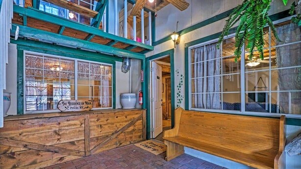 A cozy interior with a wooden bench, a sign reading "The Residence on Main," and a brick floor. - The Residence on Main (Pioche)