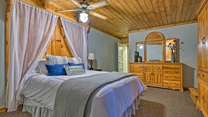 A bedroom with a canopy bed, wooden ceiling, and a dresser with multiple drawers. - The Residence on Main (Pioche)