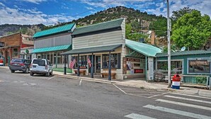 A small-town street with a building labeled "Atlas Tires" and a parked car. - The Residence on Main (Pioche)