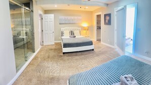 A bedroom with a bed, a glass shower enclosure, a walk-in closet, and a door leading to another room. - "Monthly Stay • Pool - WiFi - Parking - Near Strip (Las Vegas)