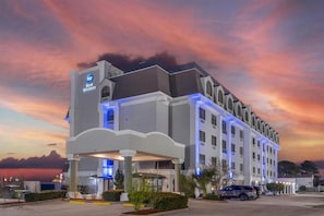 Ein Hotel mit modernem Design, einem überdachten Eingang und einem Parkplatz.