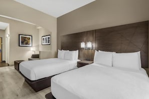 Una camera d'albergo con due letti, un ampio specchio, opere d'arte a parete e un design moderno.